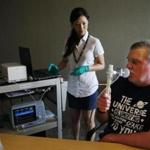 A patient used a breathalyzer for fungal infections as Dr. Xinewi Yu helped monitor his breathing. 