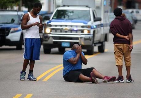 A man grieved in the middle of Hancock Street, where a double shooting left one person dead and another injured Thursday. 
