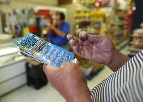 Chelsea, Massachusetts -- 06/04/2014-- A man scratches a lottery ticket at Tan-Thang Market on Broadway in Chelsea, Massachusetts June 4, 2014. Jessica Rinaldi/Globe Staff Topic: 05lotteryaid05 Reporter: 
