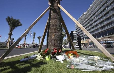 FRANCE SLIDER2 Flowers are placed at the scene of an attack after a truck plowed through a crowd in Nice, southern France, Friday, July 15, 2016. A large truck plowed through revelers gathered for Bastille Day fireworks in Nice, killing more than 80 people and sending others fleeing into the sea as it bore down for more than a mile along the Riviera city's famed waterfront promenade. (AP Photo/Luca Bruno)
