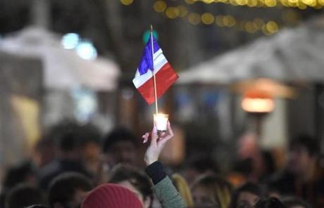 FRANCE SLIDER2 A member of the French community holds up a candle and a national flag during a vigil in Sydney on July 15, 2016. A gunman smashed a truck into a crowd of revellers celebrating Bastille Day on July 14, 2016 in the French Riviera city of Nice, killing at least 84 people in what President Francois Hollande called a 