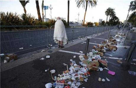 FRANCE SLIDER2 A man walks through debris scatterd on the street the day after a truck ran into a crowd at high speed killing scores celebrating the Bastille Day July 14 national holiday on the Promenade des Anglais in Nice, France, July 15, 2016. REUTERS/Eric Gaillard
