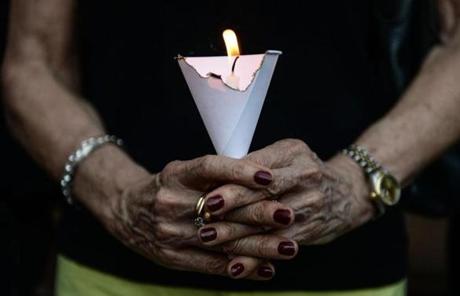 FRANCE SLIDER2 A member of the French community holds a candle during a vigil in Bangkok on July 15, 2016. A gunman smashed a truck into a crowd of revellers celebrating Bastille Day on July 14, 2016 in the French Riviera city of Nice, killing at least 84 people in what President Francois Hollande called a 