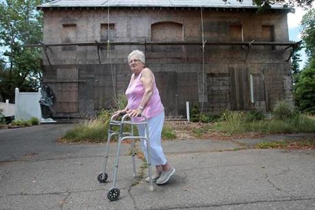 Gloria Lilja, 84, at the house that now stands gutted and boarded up in Beverly.
