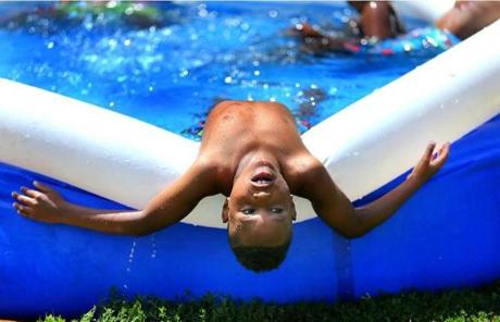 South Boston-07/23/2016- Euriel Mercedes(cq), 7, cools off in an inflatable swimming pool in front of his apartment in the Mary Ellen McCormack Housing Project. A heat wave continues in the area. Boston Globe staff photo by John Tlumacki(metro)
