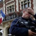 A policeman reacts as he secures a position in front of the city hall after two assailants had taken five people hostage in the church at Saint-Etienne-du -Rouvray near Rouen in Normandy, France, July 26, 2016. Two attackers killed a priest with a blade and seriously wounded another hostage in a church in northern France on Tuesday before being shot dead by French police. REUTERS/Pascal Rossignol 