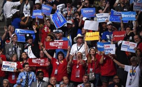Delegates hold up signs during Day 2 of the Democratic National Convention at the Wells Fargo Center in Philadelphia, Pennsylvania, July 26, 2016. / AFP PHOTO / Timothy A. CLARYTIMOTHY A. CLARY/AFP/Getty Images
