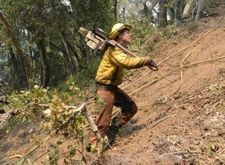 Timber faller Jeff Turpin hiked up a hillside with his chainsaw in while cutting a fire break for a wildfire in Carmel Valley, Calif., on Saturday. 
