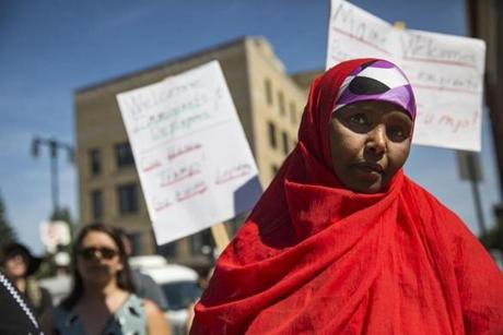 06somalis - PORTLAND, ME - AUGUST 5: Portland resident Reqiya Egal, originally from Somalia, stands amid protest signs at City Hall during a rally protesting Thursday's comments by Republican presidential nominee Donald Trump, who claimed Maine's Somali community has led to an uptick in crime. ( Ben McCanna/Portland Press Herald)

