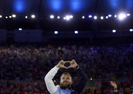 An athlete from the Israeli contingent makes the shape of a heart with his fingers as he enters the stadium.
