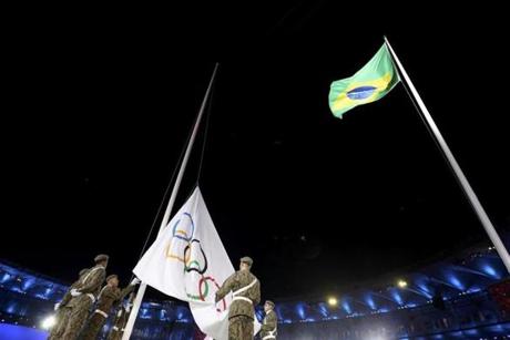 Brazilian soldiers raise the Olympic flag as the Braziilian flag flies above during the Opening Ceremony.
