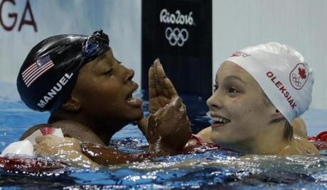 United States' Simone Manuel, left, and Canada's Penny Oleksiak celebrate winning joint gold in the women's 100-meter freestyle during the swimming competitions at the 2016 Summer Olympics, Thursday, Aug. 11, 2016, in Rio de Janeiro, Brazil. (AP Photo/Matt Slocum)
