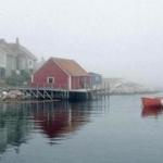 Peggy?s Cove, its weathered fishing shacks and colorful boats, in fog.