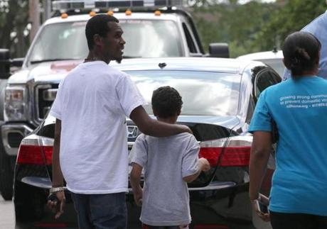 BOSTON, MA - 8/12/2016: Kelvin Martins with his uncle Luando Da Costa is led away to vehicle after being released by EMT's . The 9-year-old boy was located and is safe and sound after his father allegedly took him from a sooting scene in his car, police said. Juan Ayala-Powell, 27, left a shooting Thursday night on Blue Hill Avenue with his son, Kelvin Martins, in the green 2004 Ford Explorer. (David L Ryan/Globe Staff Photo) SECTION: METRO TOPIC 13shooting(2)
