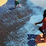 Children cooled off in a sprinkler at a Somerville park. 