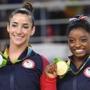 US gymnast Alexandra Raisman and US gymnast Simone Biles (R) celebrate on the podium of the women's floor event final of the Artistic Gymnastics at the Olympic Arena during the Rio 2016 Olympic Games in Rio de Janeiro on August 16, 2016. / AFP PHOTO / Toshifumi KITAMURATOSHIFUMI KITAMURA/AFP/Getty Images