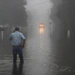 Gary Schexnayder stood in a flooded street as an early morning fog blankets the area on Wednesday in Sorrento, Louisiana. Starting last week Louisiana was overwhelmed with flood water causing at least seven deaths and thousands of homes damaged by the flood waters.