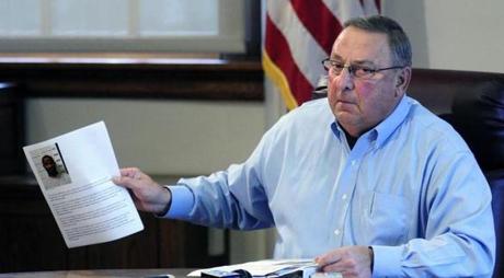 Maine Governor Paul LePage held up a news release with a booking mug shot from a three-ring binder of news releases and articles about drug arrests on Friday.
