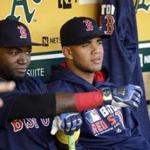 Boston Red Sox's Yoan Moncada, right, sits beside David Ortiz in the dugout prior to the team's baseball game against the Oakland Athletics on Friday, Sept. 2, 2016, in Oakland, Calif. (AP Photo/Ben Margot)
