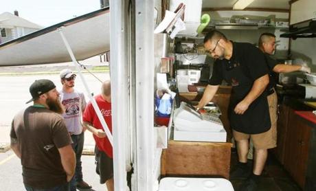 Customers line up for tacos outside a taco truck in Iowa.
