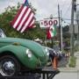 A pedestrian walked in front of a used car lot that is flying both the Mexican and American flags along Buford Highway in Norcross, Ga., late last month.
