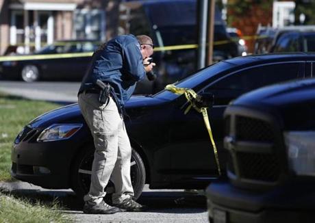 Methuen, MA - 9/12/2016 - An officer takes photographs of a car parked outside of the apartment where Wanda Rosa, 29, died her 4-year-old son was unharmed in Methuen, MA, September 12, 2016. (Jessica Rinaldi/Globe Staff) Topic: 13methuen 
