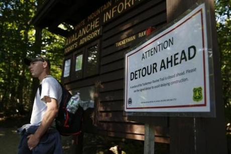 Ben Wildes, 23, of Waterboro, Maine stood beside a sign posted for a detour due to ongoing construction on the Tuckerman Ravine Trail at Pinkham Notch.  
