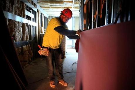 Omar Pedroza installed drywall at an East Boston apartment project. As a job foreman, he said he sometimes had to stuff cash from a subcontractor into his pockets to pay co-workers.
