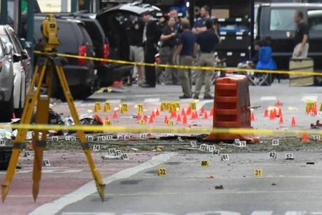 Evidence markers on the street surround police and Federal Bureau of Investigation (FBI) officials near the site of an explosion in the Chelsea neighborhood of Manhattan, New York, U.S. September 18, 2016. REUTERS/Rashid Umar Abbasi
