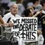 A Saints fan holds a sign referencing the presidential debate between Hillary Clinton and Donald Trump, which happened during the same time as this NFL football game between the New Orleans Saints and the Atlanta Falcons, in New Orleans, Monday, Sept. 26, 2016. The Falcons won 45-32. (AP Photo/Bill Feig)