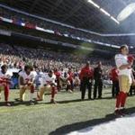 San Francisco 49ers Blaine Gabbert, right, stands as Eli Harold (58), Colin Kaepernick (7) and Eric Reid (35) kneel during the national anthem before an NFL football game against the Seattle Seahawks, Sunday, Sept. 25, 2016, in Seattle. (AP Photo/Ted S. Warren)