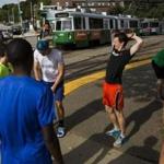 Boston, MA - 09/18/2016 - A group of runners that race against MBTA Green line trains along Commonwealth Avenue, talk as they stretch before the start of their race againsg the train in Boston, MA, September 18, 2016. The runners ran along the train's route on Commonwealth Avenue from the Boston College stop to the Blandford Street stop with the fastest time beating the train to the station by 6 minutes and 15 seconds. (Keith Bedford/Globe Staff) 