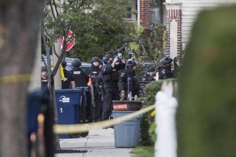 A SWAT team gathered in front of a house on Aldrich Street in Roslindale on Tuesday after gunfire was exchanged during a police operation. 
