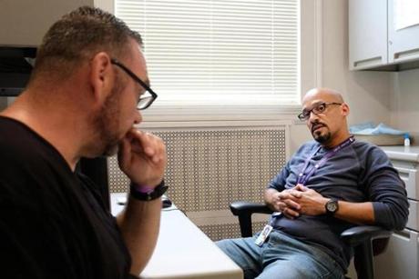 September 30, 2016 - Charlestown, MA Efrain Lozada (right) meets with Brian O'Neill to see how he's doing at Mass General Hospital in Charlestown, MA. Former drug addicts being hired as fulltime employees at Massachusetts General Hospital, one of first hospitals in the country to try this. Kieran Kesner for The Boston Globe. 
