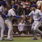 Chicago Cubs' Ben Zobrist (18) celebrates with Jason Heyward, left, and Anthony Rizzo after scoring during the ninth inning of Game 4 of baseball's National League Division Series against the San Francisco Giants in San Francisco, Tuesday, Oct. 11, 2016. (AP Photo/Marcio Jose Sanchez)