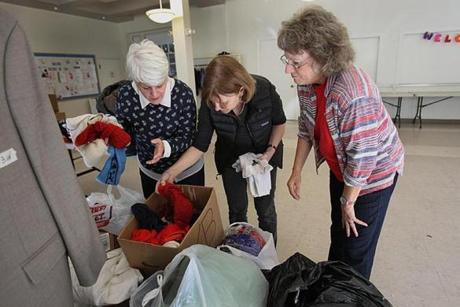 Volunteers (from left) Amanda Mujica, Susan Smith, and Holly Stratford collected winter clothes at Plymouth Congregational Church.

