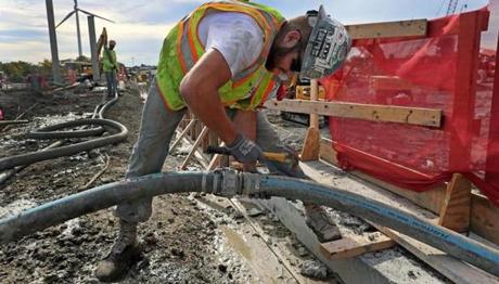 Kevin Rineer working on a cement hose at the construction site of the Wynn Casino in Everett (above). 
