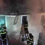 Firefighters used ladders while fighting the blaze on Myrick Street in Allston in August.