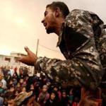 An Iraqi soldier tried to calm displaced people who were seeking food at a processing center in Qayyara, Iraq, on Sunday. 