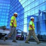 Workers passed by the new Mohegan Sun Hotel, which reflected the original hotel. The new facility is expected to open next month.