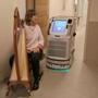Margot Chamberlain paused in playing her harp so that Lucy, the pharmacy robot, can pass by at Dana-Farber Cancer Institute. The robot brings drugs directly to patients. 