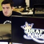 FILE - In this Sept. 9, 2015, file photo, Len Don Diego, marketing manager for content at the DraftKings daily fantasy sports company, works at his station at the company's offices in Boston. DraftKings and FanDuel are downplaying media reports this week that the two biggest daily fantasy sports companies could team up. But given their swift change of fortune this past year, industry watchers say the timingâ??s right for a deal. (AP Photo/Stephan Savoia, File)