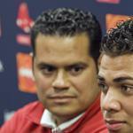 Boston Red Sox director of international scouting Eddie Romero (L) listens as Cuban baseball player Yoan Moncada speaks to reporters at the Boston Red Sox training complex in Fort Myers, Florida March 13, 2015. Moncada and the Red Sox announced a record $31.5 million deal after he passed a pending physical, according to team officials on Friday. REUTERS/Steve Nesius (UNITED STATES - Tags: SPORT BASEBALL)