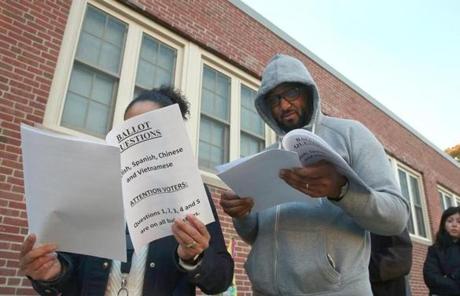 Boston, MA -11/8/2016 - Before 7 am, Barbara Najjar-Owens (cq) and Darryl Owens (cq) read information passed out by a poll worker. People turn out to vote in Hyde Park (30 Millstone Road). Photo by Pat Greenhouse/Globe Staff Topic: 09turnout Reporter: XXX
