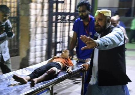 Pakistani rescuers transported an injured boy to a hospital in Karachi following a suicide bombing at a Sufi shrine.
