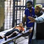 Pakistani rescuers transported an injured boy to a hospital in Karachi following a suicide bombing at a Sufi shrine.
