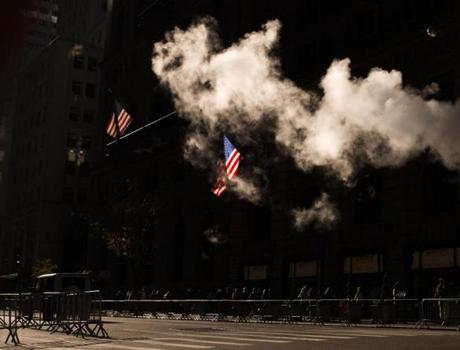 People walked in between security fences as steam rose from under the street near Trump Tower in New York on Friday. 
