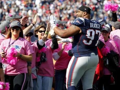New England Patriots defensive tackle Alan Branch high fives supporters of breast cancer awareness month before an NFL football game against the Cincinnati Bengals at Gillette Stadium in Foxborough, Mass. Sunday, oct. 16, 2016. (Winslow Townson/AP Images for Panini)
