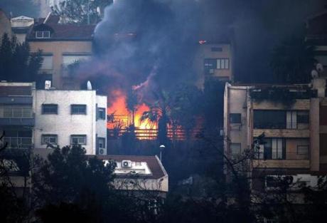 Smoke billowed from a house as a fire raged in the northern Israeli port city of Haifa on Thursday. 
