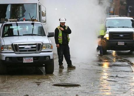 Boston-11/30/2016- A manhole cover is rattling on Kneeland Street as workers move away from it after a watermain break on Washington Street in Chinatown flooded the street and some businesses, and left several inches of mud on the street at by 9 a.m. John Tlumacki/Globe Staff (metro)
